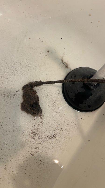 Responded to a clogged upstairs hallway bathroom shower drain in a 31-year-old residential property. Upon inspection, identified a significant accumulation of hair and organic debris obstructing the drain line. Successfully removed the blockage by extracting the matted hair mass and associated buildup from the drain assembly, restoring proper water flow and drainage function to the shower.