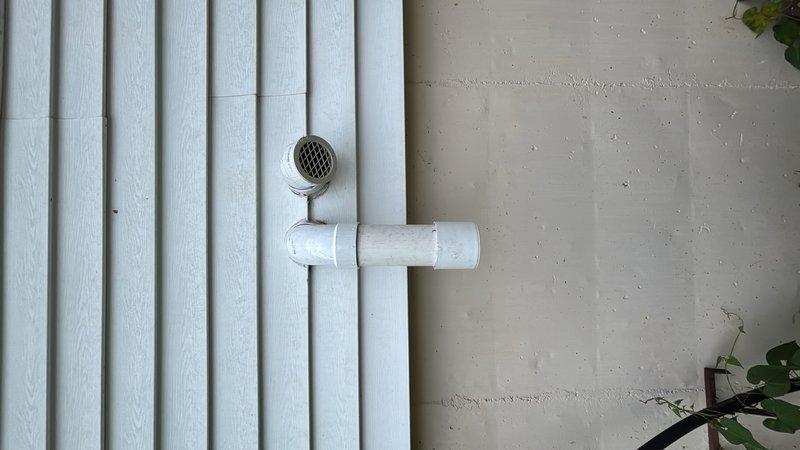 Relocated and reinstalled the air intake and exhaust venting system for the tankless water heater. Reconfigured the PVC pipe assembly on the exterior of the home, installing proper T-junction fittings and screened termination caps with mesh covers to ensure adequate ventilation and code compliance. The new configuration provides improved air supply and exhaust discharge for optimal unit performance and safety.