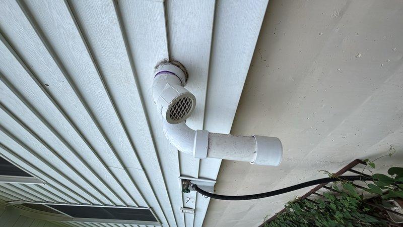 Relocated and reinstalled the air intake and exhaust venting system for the tankless water heater. Reconfigured the PVC pipe assembly on the exterior of the home, installing proper T-junction fittings and screened termination caps with mesh covers to ensure adequate ventilation and code compliance. The new configuration provides improved air supply and exhaust discharge for optimal unit performance and safety.