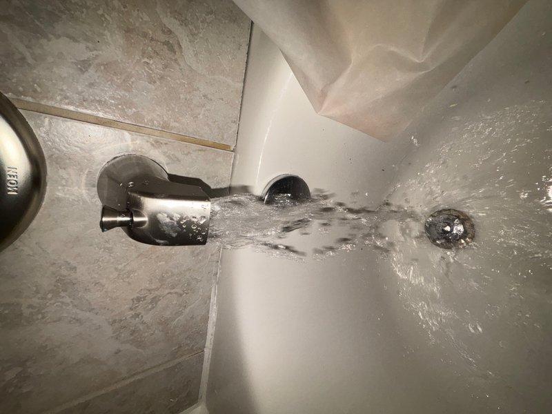 Completed installation of customer-provided bathroom fixtures in main level bathroom of split-level home. Installed new chrome tub spout and oil-rubbed bronze showerhead assembly with curved wall-mounted arm, replacing existing fixtures. Verified proper water flow, tested for leaks, and confirmed all connections were secure upon completion.