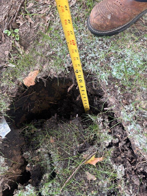 Responded to site with settling issue near concrete step. Measured excavated hole depth and documented 8-9 inch elevation difference at concrete edge. Added fill dirt to settling area to restore proper grade and prevent further subsidence around foundation perimeter.