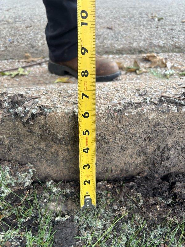 Responded to site with settling issue near concrete step. Measured excavated hole depth and documented 8-9 inch elevation difference at concrete edge. Added fill dirt to settling area to restore proper grade and prevent further subsidence around foundation perimeter.