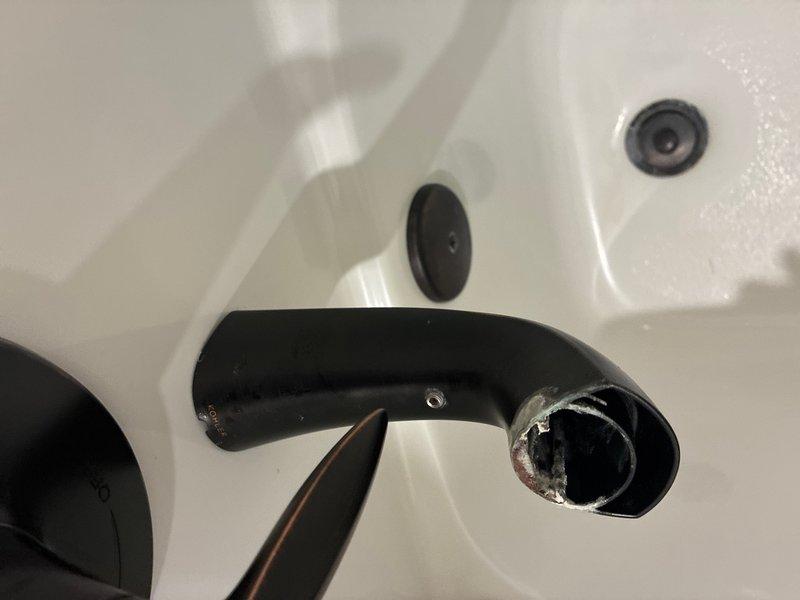 Responded to guest bathroom service call for malfunctioning tub/shower faucet. Upon inspection, discovered the bathroom sink faucet spout had become detached from its mounting post, with visible corrosion and mineral buildup on the internal connection hardware. Disassembled the black faucet components to assess the extent of deterioration on the mounting mechanism and connecting points. Documented the condition of the fixtures showing significant wear, tarnishing, and mineral deposits around the spout opening and internal hardware that contributed to the failure. Provided assessment and repair recommendations for proper fixture restoration.