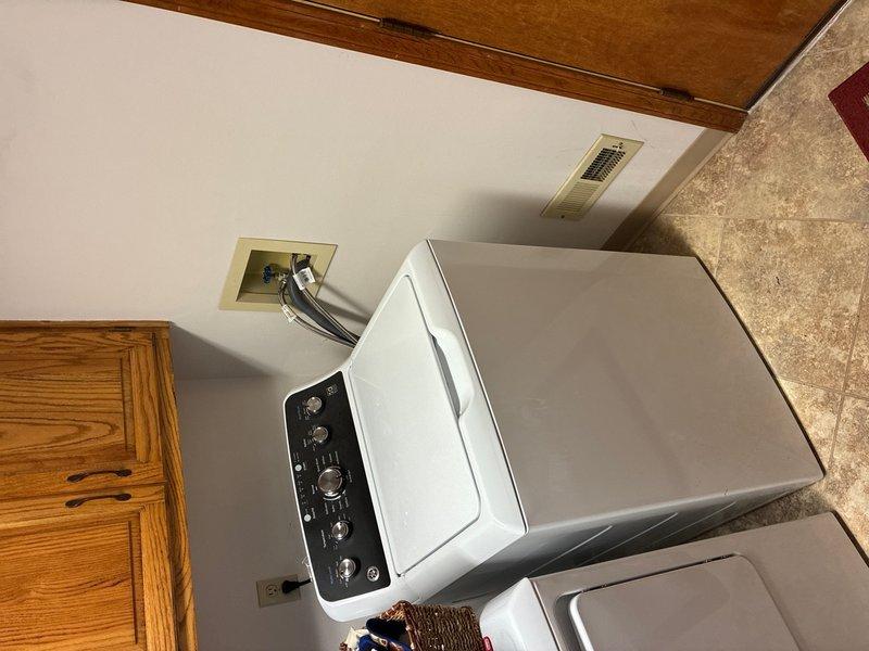 Responded to water leak complaint in main floor laundry room. Upon inspection, identified sump pump system as source of moisture issue affecting laundry room wall. Inspected sump basin, pump assembly, discharge piping, and check valve components. Documented existing conditions including water staining patterns on basin walls and proper pump installation with PVC discharge lines. Verified laundry appliances and surrounding areas for additional moisture concerns. Photographed sump pump system and laundry room configuration for service records.