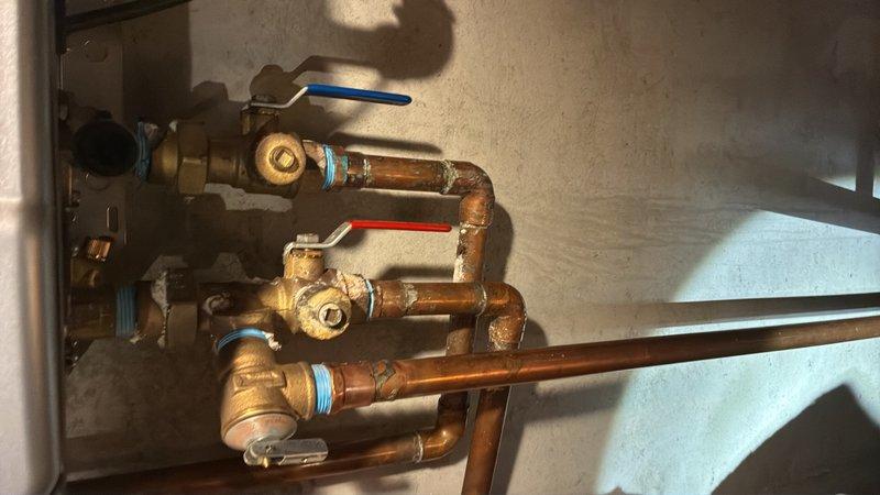 Performed annual preventive maintenance on iTech tankless water heater system, including complete system flush to remove mineral buildup and ensure optimal performance. Inspected all water connections, gas lines, and electrical components for proper operation and safety compliance. Verified proper function of hot and cold water isolation valves with blue and red handles on the copper manifold assembly. Tested unit controls, digital display, and operational settings. Confirmed adequate venting and clearances around the unit. System operating within manufacturer specifications upon completion.
