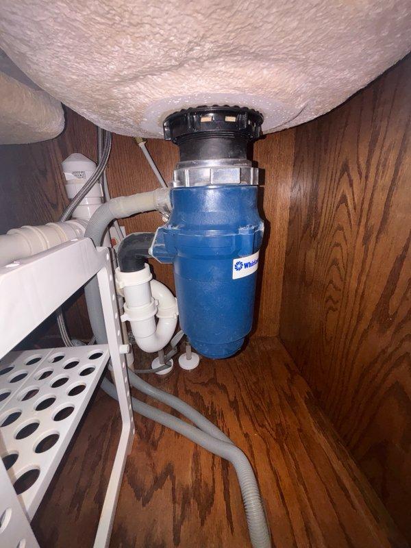 Replaced garbage disposal unit in kitchen sink with new blue model, securing mounting flange and connecting electrical supply. Investigated reported low water pressure issue at kitchen sink faucet, inspecting supply lines and aerator for blockages or restrictions. Verified proper drainage through P-trap configuration and tested disposal operation to ensure functionality.