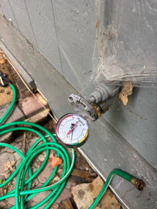 Completed comprehensive plumbing inspection to address concerns regarding water usage and potential leak detection. Performed visual assessment of all accessible plumbing fixtures, supply lines, and drainage systems throughout the property. Inspected exterior pressure gauge and hose connection points for signs of leakage or abnormal pressure readings. Examined basement utility area plumbing infrastructure, including copper water supply lines, PVC drainage pipes, shutoff valves, and connection fittings mounted to concrete wall. Evaluated water heater installation, associated piping configuration, and brass valve assemblies for proper operation and potential leak sources. Documented system conditions with photographic evidence showing pressure monitoring equipment and plumbing distribution network. No active leaks identified during inspection period. All visible pipe connections, joints, and valve assemblies appeared secure with no signs of moisture, corrosion, or water damage on surroun