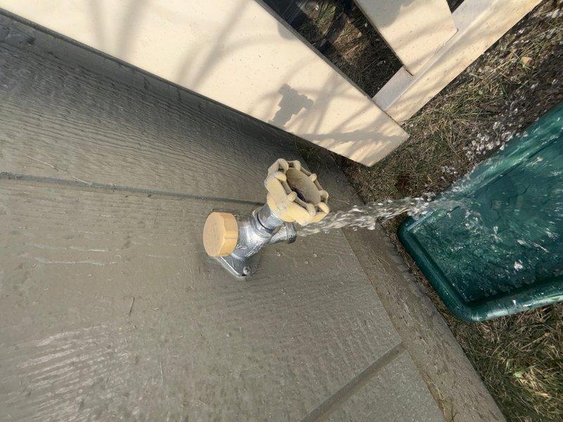 Completed comprehensive whole home plumbing inspection of residential property. Examined interior bathroom fixtures including toilet installation, water supply connections, and shut-off valve operation, noting standard configuration with braided stainless steel supply line in good working condition. Inspected exterior hose bibb with freeze protection insulation cover, tested water flow and valve operation to ensure proper function for seasonal use.