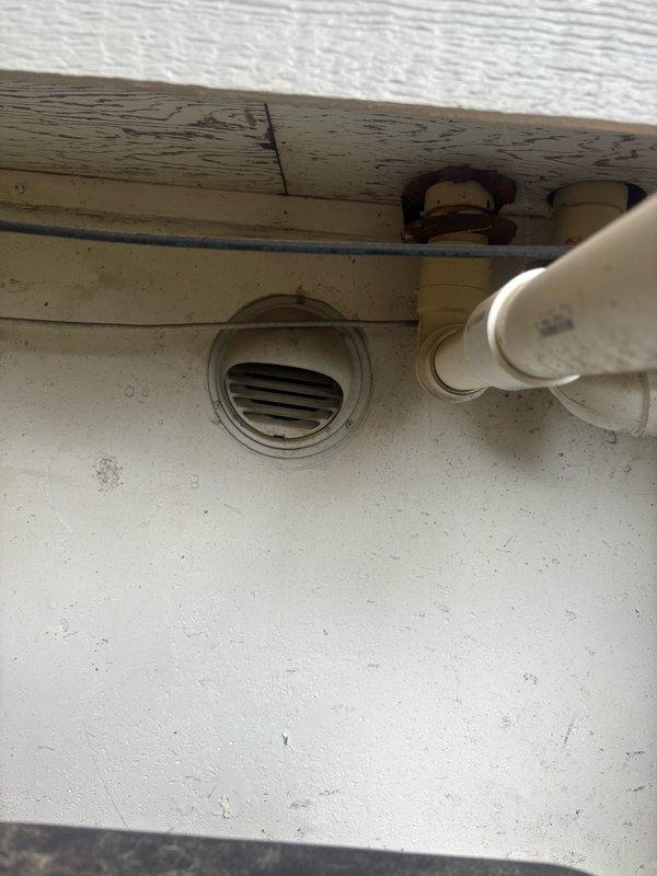 Responded to service call for non-operational tankless water heater. Upon arrival, conducted comprehensive diagnostic inspection of the water heating system and associated plumbing infrastructure. Examined exterior venting components, including PVC exhaust piping and louver vent installation to verify proper combustion air flow and exhaust discharge. Inspected interior utility area where water treatment equipment, including active water softener unit with copper supply lines, was noted in proximity to the water heating system. Evaluated all visible plumbing connections, supply lines, and system integration points. Documented existing conditions through photographic records showing exterior vent configuration and interior utility space layout for service records and repair recommendations.