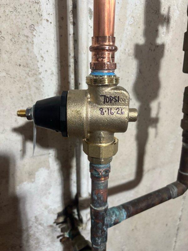 Responded to reported leaking copper pipe in basement. Upon inspection, identified deteriorated section of copper piping with visible corrosion and oxidation damage below the shutoff valve. Replaced compromised pipe section using press-fit coupling connection method. Installed new copper pipe segment with modern press-style fitting featuring ridged dual-ring design to ensure secure, leak-free connection. Verified valve assembly integrity and tested system for proper operation and water-tight seal upon completion.