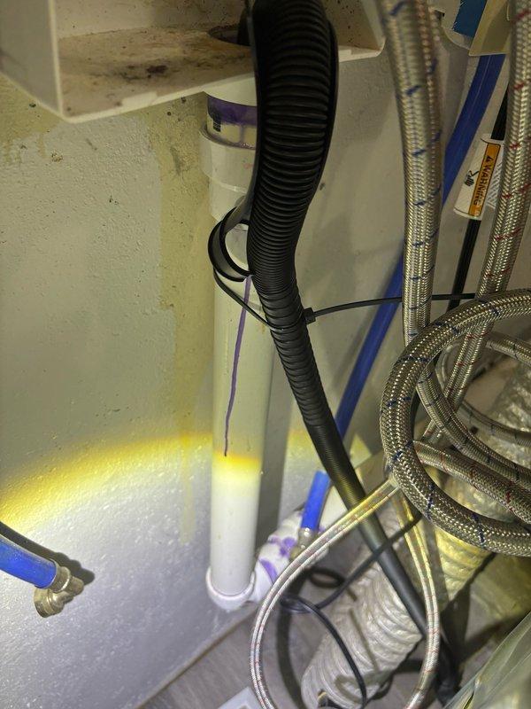 Responded to complaint of bathroom sink backing up when washing machine drains. Upon inspection, identified drainage issue in shared waste line serving both washing machine and nearby bathroom fixtures. Located problematic plumbing configuration in basement utility area where washing machine discharge connects to main drain stack. Cleared obstruction from horizontal drain line using appropriate mechanical methods. Verified proper drainage flow from washing machine through PVC drainage system and confirmed bathroom sink now drains freely without backup during washing machine operation. Tested system through multiple cycles to ensure complete resolution of cross-fixture drainage problem.