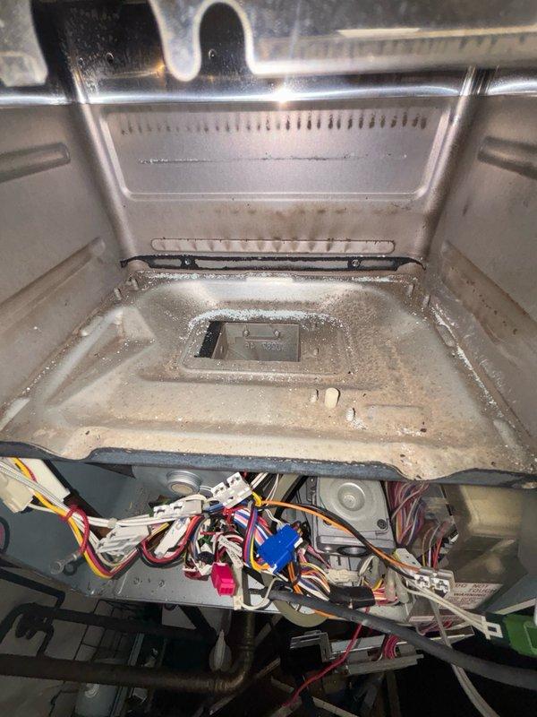 Responded to service call for tankless water heater experiencing intermittent shutoff with no error code displayed. Upon arrival, removed access panels to perform comprehensive diagnostic inspection of unit's electrical components and internal systems. Examined wiring harness, connections, and control board for loose connections, corrosion, or signs of electrical failure. Inspected heat exchanger coils and found evidence of mineral buildup and condensation accumulation affecting unit performance. Cleaned heat exchanger fins and drainage components, removed debris from interior compartment, and verified proper drainage function. Tested all electrical connections and control sequences to ensure proper operation. Cycled unit through multiple heating cycles to confirm resolution of shutoff issue and verified stable operation without fault codes.