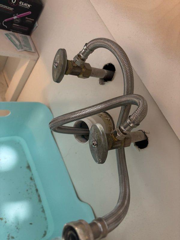 Replaced bathroom shut off valves on main level with new chrome-finished quarter-turn valves and braided stainless steel flexible supply lines. Removed old corroded valves, installed new units with escutcheons flush-mounted to wall, and connected supply lines to ensure proper water flow control to bathroom fixtures.