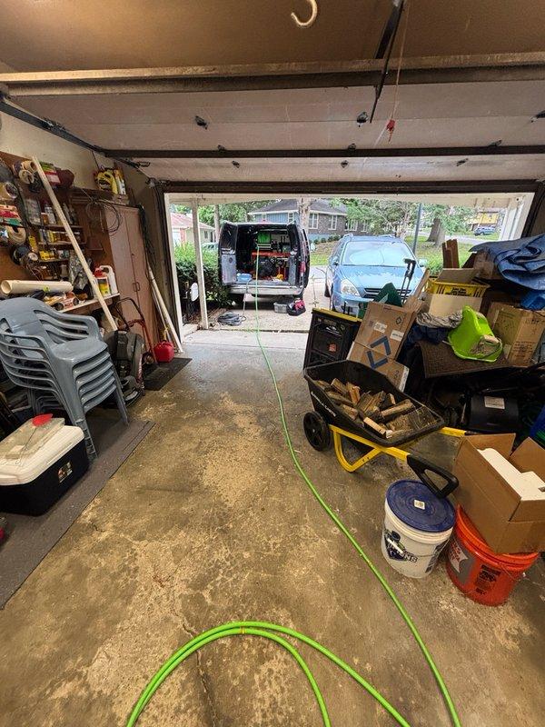 Performed hydro-jetting service on interior drain line in residential basement utility area. Deployed jetting equipment from service vehicle through garage access point, routing hose through residential space to reach basement drain system. Successfully cleared blockage and restored proper drainage flow through affected line. Water heater and surrounding plumbing connections remained protected during service operation. Removed equipment upon completion and confirmed drain functionality.