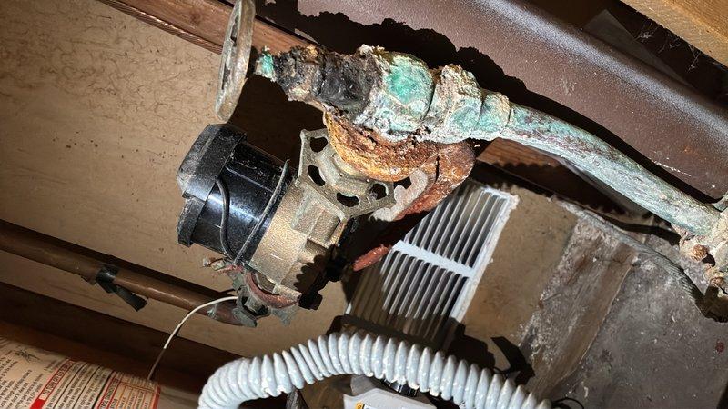 Completed comprehensive assessment of deteriorated water main system requiring full replacement. Documented extensive corrosion on existing copper water service line, including severe oxidation with green patina, rust deposits, and mineral buildup concentrated at connection joints. The corroded pipe assembly showed significant degradation that compromised system integrity and posed risk of failure.

Evaluated associated components including brass valve assembly, pump unit, and connecting fixtures, all exhibiting age-related deterioration and corrosion. Provided detailed photographic documentation of all affected plumbing infrastructure to support replacement estimate for complete water main installation.