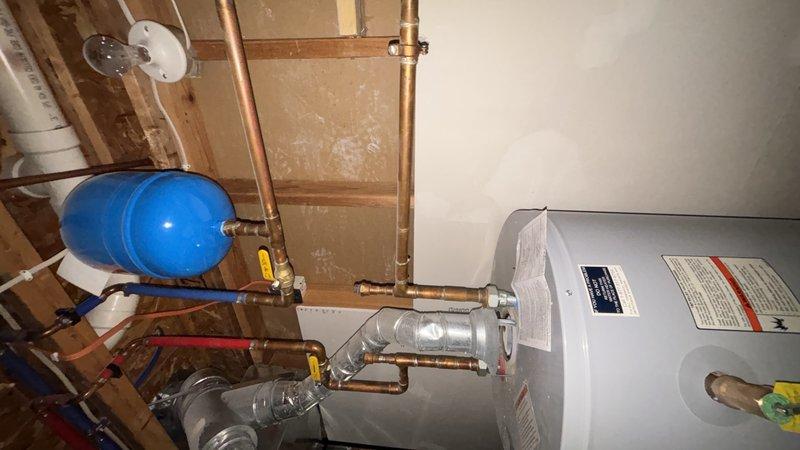 Responded to call for basement drain backup near water heater and furnace area with recurring flooding issues. Upon arrival, observed third-floor toilet causing gurgling sounds in plumbing system and triggering basement floor drain overflow when flushed. Performed main line cleanout to clear obstruction in primary drainage system. Removed blockage causing air trap conditions and restoring proper venting throughout vertical plumbing stack. Tested system by flushing third-floor toilet multiple times and verified basement drain no longer backing up. Confirmed proper drainage flow and elimination of gurgling sounds in fixtures.