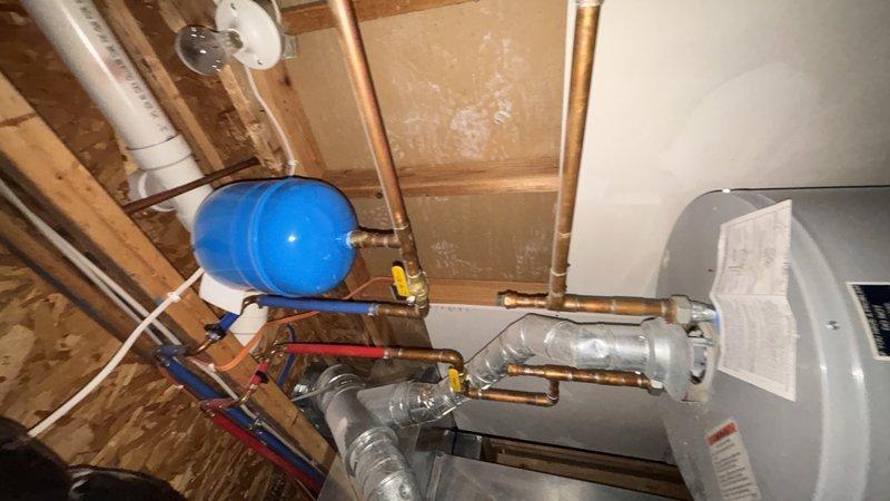 Responded to call for basement drain backup near water heater and furnace area with recurring flooding issues. Upon arrival, observed third-floor toilet causing gurgling sounds in plumbing system and triggering basement floor drain overflow when flushed. Performed main line cleanout to clear obstruction in primary drainage system. Removed blockage causing air trap conditions and restoring proper venting throughout vertical plumbing stack. Tested system by flushing third-floor toilet multiple times and verified basement drain no longer backing up. Confirmed proper drainage flow and elimination of gurgling sounds in fixtures.