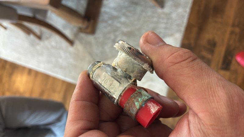 Responded to service call for gas line inspection at fireplace and multiple water leaks in bathroom and utility closet. Inspected gas line to fireplace and capped off as needed per customer request in preparation for home sale. Addressed water supply valve leak in bathroom, which showed signs of corrosion and deterioration on the shut-off valve assembly and copper supply line connections. Repaired or replaced corroded valve components exhibiting green patina and mineral buildup at threaded connections. Investigated water leak in utility closet adjacent to water heater and performed necessary repairs to eliminate active leaks. Documented all findings and repairs with photos for service records.