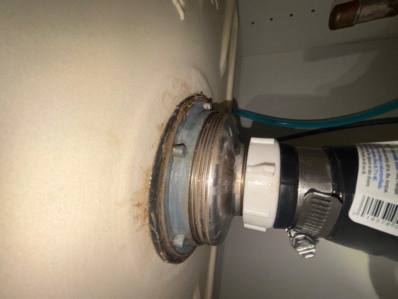 Responded to reported water leak in kitchen and bathroom areas. Upon inspection, identified leaking supply line connection at wall-mounted fixture showing visible rust staining and moisture damage on surrounding white surface. Tightened threaded metallic fitting and secured flexible supply hose with hose clamp to eliminate leak at connection point. Inspected under-sink plumbing infrastructure in cabinet, examining PVC drain trap assembly, multiple pipe joints, and supply line connections. Verified all connections were properly secured and leak-free. System tested and confirmed operational with no active leaks present at time of service completion.