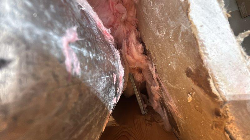 Responded to report of water leak in garage ceiling that occurred when water was used inside the home. Upon arrival, accessed the area above the garage ceiling to investigate the source of the leak. Inspection revealed compromised plumbing line or connection within the floor joist cavity above the affected area. Documented existing conditions including disturbed insulation and structural access points near HVAC ductwork. Identified active leak source requiring repair of water supply line. Provided estimate for necessary repair work to resolve the leak issue and prevent further water damage to the ceiling below.