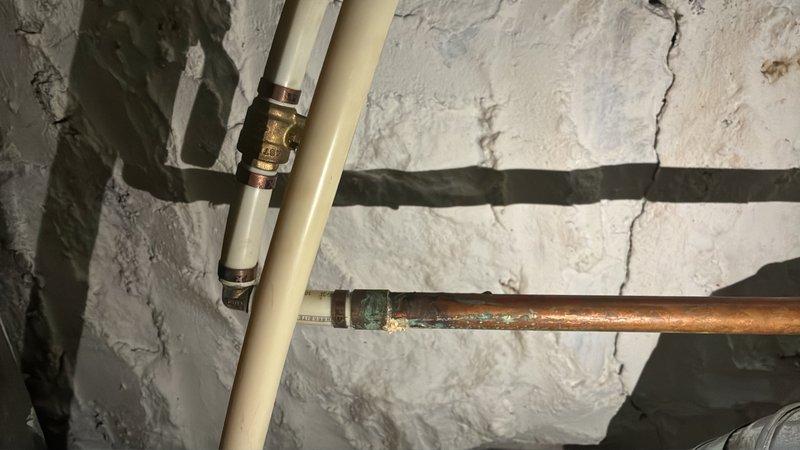 Conducted on-site evaluation of 25+ year old gas water heater in basement showing signs of active failure. Assessed existing 50-gallon gas unit, documented corroded copper supply lines with significant green patina oxidation, and evaluated surrounding plumbing infrastructure including condition of pipe connections and fittings. Provided detailed estimate for replacement of aging water heater system with new 50-gallon gas unit, including necessary updates to deteriorated supply piping and proper venting requirements.