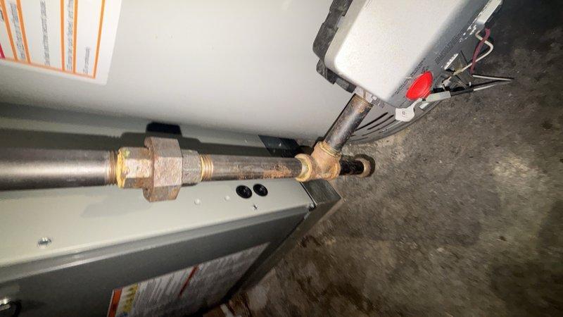 Completed routine plumbing maintenance inspection of residential property. Inspected HVAC-related copper piping with brass compression fittings in mechanical room, noting age-related discoloration on components but confirming system integrity. Examined bathroom vanity plumbing including sink drain assembly and PVC piping, verifying proper drainage and connection security with no leaks detected.
