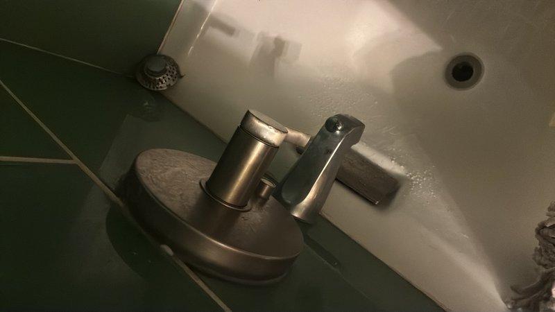 Responded to service call for multiple faucet issues throughout the property. Replaced cartridges in two wall-mounted two-handle bathroom faucets after coordinating building water shutoff and using penetrating lubricant to remove seized components. Addressed dripping kitchen faucet and applied fresh silicone caulk to deteriorated areas in kitchen and bathroom sink installations to prevent water intrusion and ensure proper sealing.