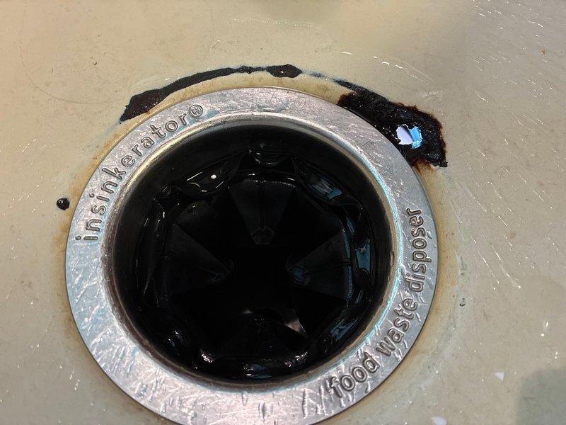 Responded to moisture sensor alert indicating water leak under kitchen sink. Upon inspection, identified InSinkErator Badger series garbage disposal as the source of the leak. Observed deteriorated rubber gasket seal between the disposal mounting flange and sink basin, allowing water to escape during disposal operation. Disassembled the disposal mounting assembly, removed the compromised gasket material, and installed a new rubber seal. Reassembled and properly torqued the mounting bolts to manufacturer specifications. Tested the disposal with running water to verify proper seal and confirm no additional leakage. Inspected adjacent water filtration system connections and supply lines for any secondary moisture issues; all connections found secure with no evidence of leakage. Cleaned work area and verified all components functioning correctly before completion.