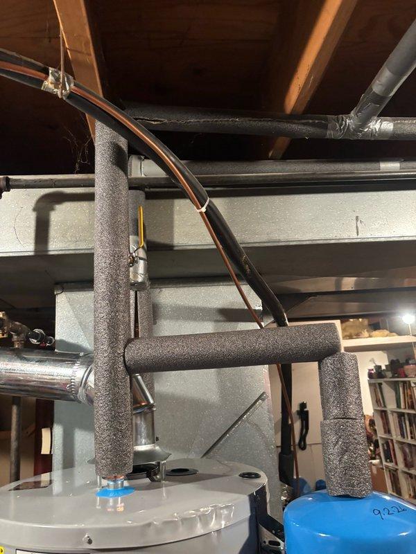 Completed installation of a 40-gallon gas water heater with thermal expansion tank in utility area. Properly connected all supply and discharge piping with copper lines, installed appropriate insulation on water lines for thermal efficiency, and integrated the blue thermal expansion tank to protect against pressure buildup in the closed system. All connections were tested and verified operational, with equipment positioned for proper clearances and ventilation requirements per manufacturer specifications.