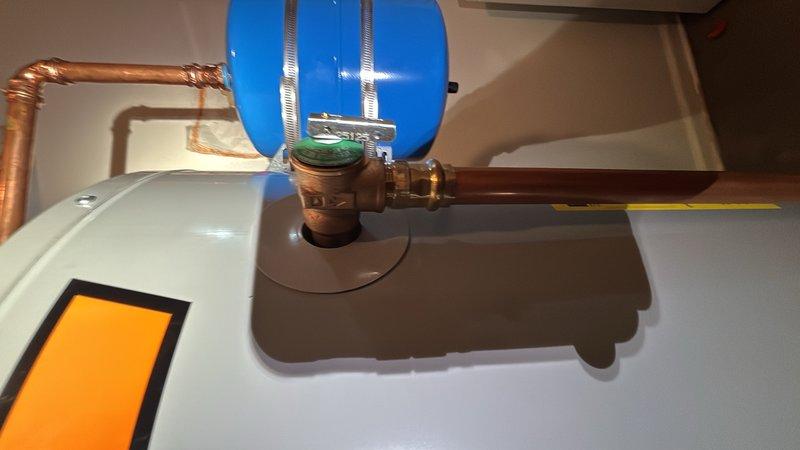 Responded to basement plumbing service call for clogged floor drain and leaking water heater. Upon inspection, addressed the main drain cleanout to restore proper drainage flow. Evaluated water heater system and associated components including expansion tank, pressure relief valve, and copper supply lines for source of reported leak. Documented equipment condition and plumbing configuration with detailed photographs for service records.
