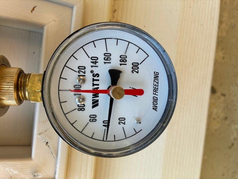 Conducted on-site evaluation of 30-year-old gas water heater located in basement to provide replacement estimate. Inspected existing 40-gallon Rheem gas unit with standard copper piping connections, brass shutoff valves, and galvanized venting system. Unit currently operational but at end of service life. Assessed plumbing configuration including hot and cold water lines with shutoff valve, pressure relief valve connections, and gas line setup. Reviewed system pressure via mounted gauge reading approximately 20 PSI. Documented existing installation including copper supply lines with natural patina, flexible gas connector, and concrete floor mounting location. Provided comprehensive estimate for replacement with new 40-gallon gas water heater including necessary connections, venting, and code-compliant installation.