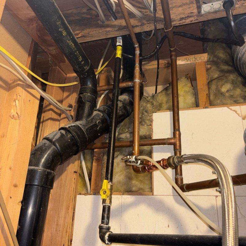 Responded to reported gas odor at tanked gas water heater in basement that began following recent HVAC service appointment. Upon inspection, identified yellow flexible gas line (CSST) routing and connections in utility area with multiple plumbing supply lines, drainage systems, and mechanical equipment. Performed thorough safety inspection of gas water heater installation, examined all gas line connections, fittings, and shutoff valves for proper installation and potential leak points. Verified proper venting configuration and clearances around unit to ensure safe operation and code compliance.