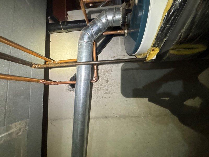 Responded to a water leak in a copper pipe located above the hot water heater in the crawl space. Upon arrival, found that a previous repair attempt had been unsuccessful. Accessed the affected area and identified the leak point on the copper supply line. Shut off the water supply to isolate the section requiring repair. Cut out the damaged portion of the copper pipe and prepared clean pipe ends for repair. Installed a new section of copper pipe using proper fitting techniques and secured connections with appropriate solder joints. Tested all connections for leaks and verified proper water flow restoration. Inspected surrounding pipes and mechanical systems for any additional concerns. Restored water supply and confirmed system operation with no further leakage detected.