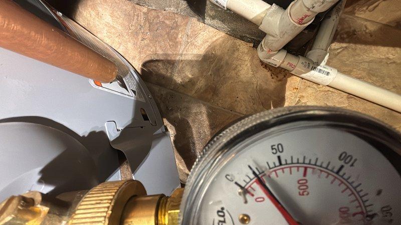 Responded to low water pressure complaint affecting entire residential property. Upon investigation, diagnosed insufficient pressure at main water supply line using pressure gauge, which confirmed readings near zero PSI. Replaced faulty pressure regulator valve and associated brass fittings to restore proper water pressure throughout the home.