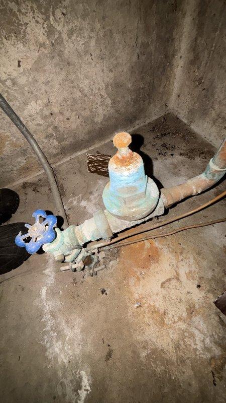 Responded to low water pressure complaint affecting entire interior of residence while outdoor pressure remained normal. Upon inspection, located main water shutoff valve in basement where supply line enters from street. Found gate valve assembly heavily obstructed with severe mineral deposits, corrosion, and calcium buildup throughout the valve body and internal components. The extensive calcification was restricting water flow and causing the pressure loss throughout the home's interior plumbing system. Disassembled and cleaned the main shutoff valve, removing accumulated mineral scale and corrosion. Verified water heater connections and copper supply lines were clear of obstructions. Restored full water flow and pressure to all interior fixtures. Tested system operation and confirmed normal pressure restored throughout residence.