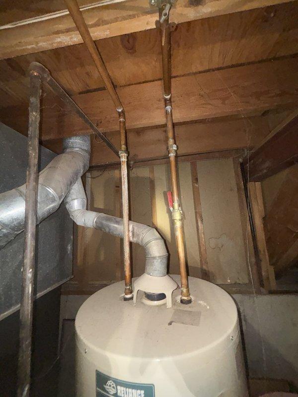 Responded to low water pressure complaint affecting entire interior of residence while outdoor pressure remained normal. Upon inspection, located main water shutoff valve in basement where supply line enters from street. Found gate valve assembly heavily obstructed with severe mineral deposits, corrosion, and calcium buildup throughout the valve body and internal components. The extensive calcification was restricting water flow and causing the pressure loss throughout the home's interior plumbing system. Disassembled and cleaned the main shutoff valve, removing accumulated mineral scale and corrosion. Verified water heater connections and copper supply lines were clear of obstructions. Restored full water flow and pressure to all interior fixtures. Tested system operation and confirmed normal pressure restored throughout residence.