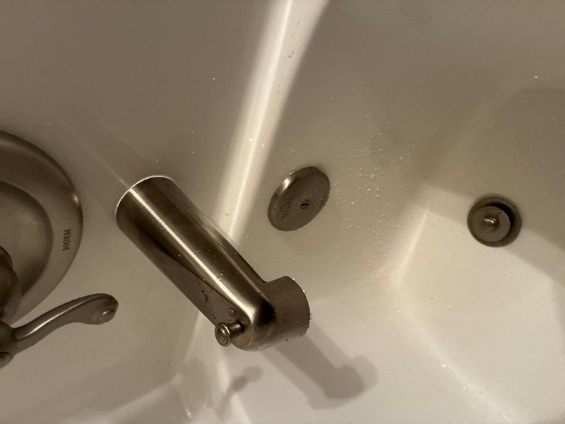 Responded to service call addressing three plumbing issues in residential bathrooms. Replaced faulty toilet flapper valve that was causing tank leakage, removing the stuck original flapper and installing new red rubber replacement component to restore proper seal and eliminate water waste. Installed customer-provided bathtub spout diverter assembly on Moen tub fixture after original water redirection mechanism failed, securing new brushed metal spout with proper mounting hardware. Reinstalled bathroom sink pop-up drain stopper assembly, reconnecting pivot rod and linkage to restore proper drain operation.