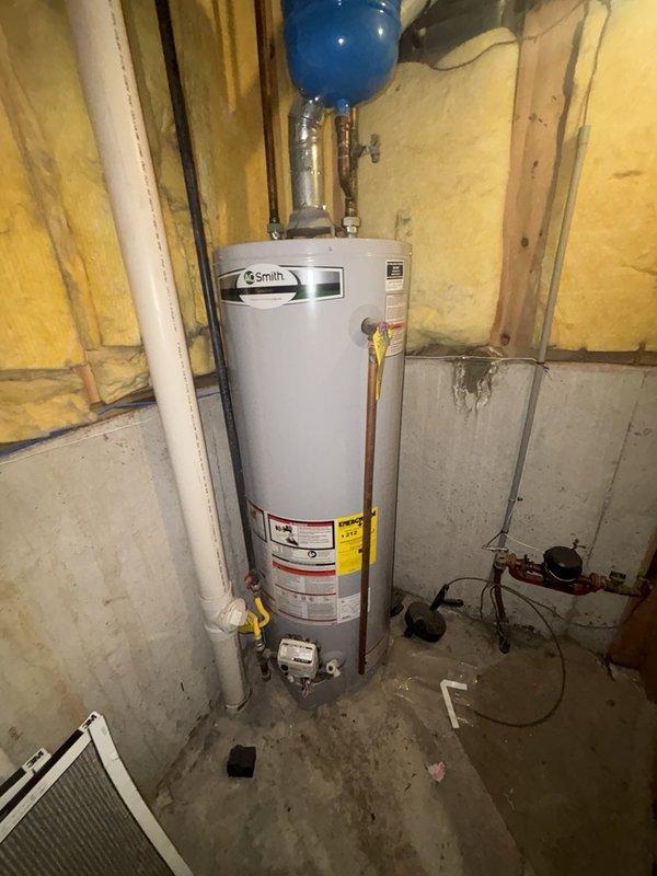 Responded to service call for no hot water and malfunctioning toilet flush valve in main bathroom. Inspected gas-fired A.O. Smith water heater in basement utility area and verified lack of hot water production throughout home. Examined toilet tank components and identified failed flush valve requiring replacement due to mineral buildup and component wear. Replaced defective flush valve assembly with new unit, tested flushing mechanism for proper operation, and verified tank refill cycle functioning correctly.