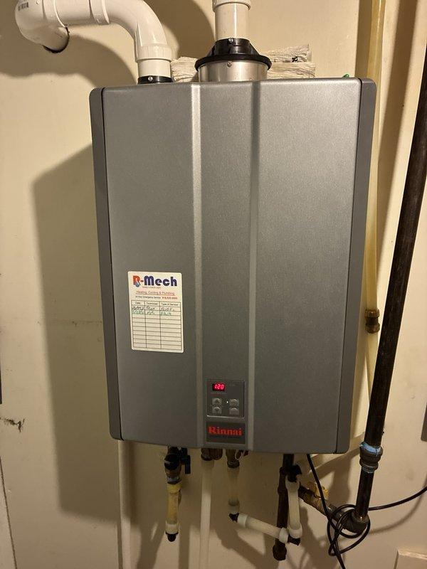 Performed plumbing maintenance visit on Rinnai tankless water heater system. Inspected unit operation, verified proper functioning of digital display showing temperature reading of 212°F, and examined all water supply connections with shutoff valves. Documented system pressure readings via mounted gauge showing parameters within normal operating range. Confirmed exhaust venting system integrity with PVC piping properly secured and all connections tight.