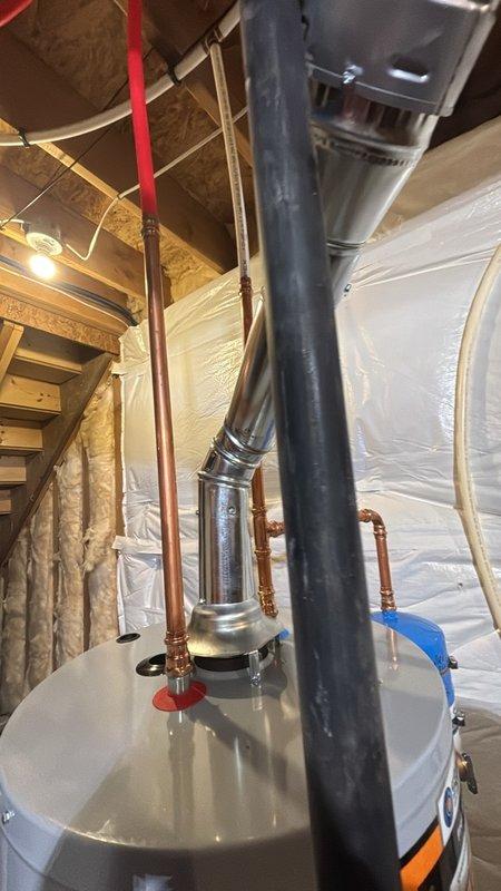 Completed installation of a 50-gallon gas-fired water heater in basement utility space. Installed thermal expansion tank to protect against excessive pressure buildup in the closed plumbing system. Connected all necessary copper supply lines with proper shut-off valves and installed pressure relief valve with discharge piping. Configured gas supply connection and venting system using code-compliant black pipe and galvanized vent piping with appropriate elbow fittings to ensure safe exhaust of combustion gases. All plumbing connections were pressure-tested and verified for proper operation. Unit was commissioned and confirmed to be heating water efficiently with no leaks detected at any connection points.