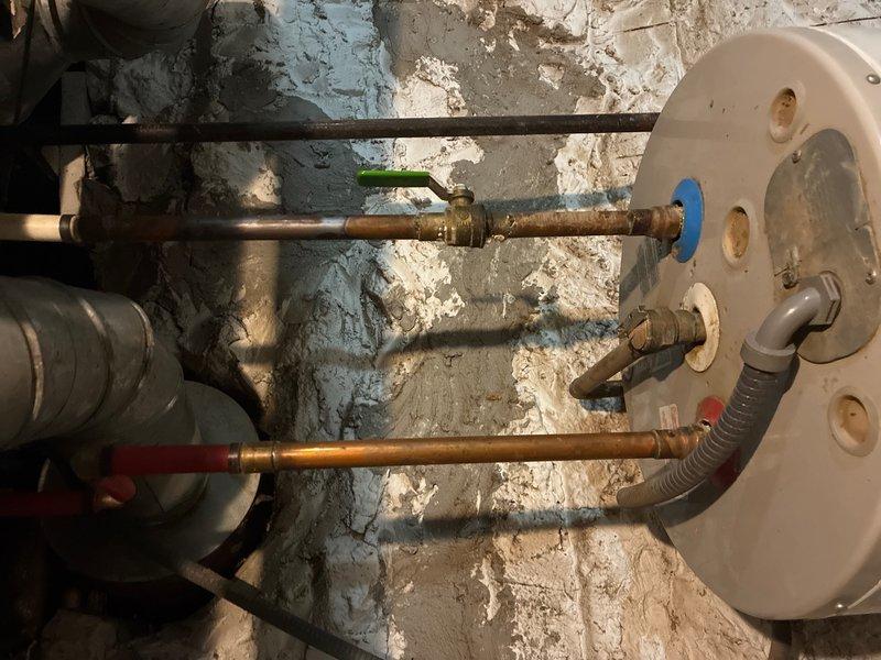 Responded to service call for malfunctioning water heater temperature regulator in basement location. Upon arrival, performed diagnostic assessment of tanked water heater system and associated components. Tested water pressure using calibration gauge to establish baseline system parameters and identify potential contributing factors to temperature regulation failure. 

Inspected copper supply lines, shut-off valves, and connection points for proper operation and signs of deterioration. Examined temperature and pressure relief valve functionality and verified proper installation of flexible connector at tank base. Evaluated condition of existing piping infrastructure, including valve controls and brass fittings throughout the system.

Replaced defective temperature regulator component, restoring proper thermostat control functionality to the water heater unit. Verified all connections were secure and system was operating within normal parameters. Tested hot water output temperature at m