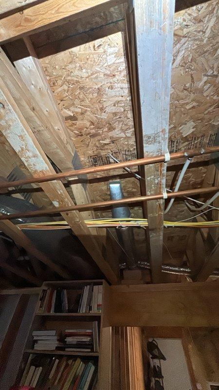 Installed new gas line routing through basement and attic space to accommodate customer's new stove installation. Ran copper piping along existing structural framework and joists, securing lines properly to wooden beams with appropriate brackets and supports. Completed installation with all connections tested and verified for safe operation.