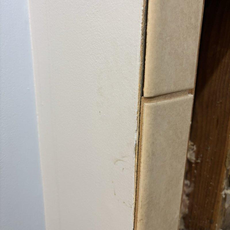 Replaced existing three-handle shower valve with new Moen Posi-Temp single-handle pressure-balancing valve. Created access point through adjacent side wall to facilitate installation, then installed oversized three-handle escutcheon trim plate to conceal previous valve mounting holes in tiled shower wall.