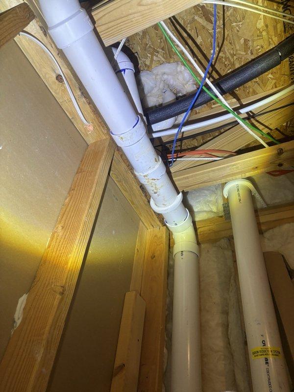 Responded to report of slow leak at master bathroom shower drain. Accessed plumbing system from basement below to inspect drain lines and connections. Upon investigation, discovered significant water staining and corrosion around shower drain assembly, indicating prolonged moisture exposure. Inspected PVC drain piping running through floor joists and confirmed leak origin at drain flange connection. Documented existing conditions showing deteriorated drain seal and mineral buildup on drain components. Provided assessment of leak source and recommended repair options to address compromised drain assembly and prevent further water damage to structure.