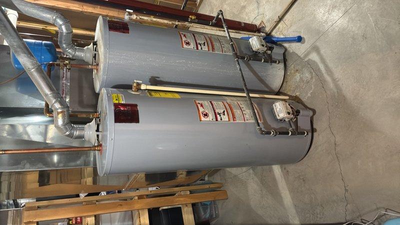 Conducted on-site evaluation for tankless water heater installation in large residential property. Assessed existing traditional tank-style water heating system consisting of two large-capacity cylindrical units currently installed in basement utility area. Examined existing plumbing infrastructure, including copper supply lines, brass fittings, and venting configurations to determine compatibility requirements for tankless system conversion. Evaluated structural support, gas line capacity, electrical requirements, and ventilation pathways necessary for new tankless unit installation. Documented current equipment specifications and mechanical room layout to prepare comprehensive estimate for tankless water heater replacement project.