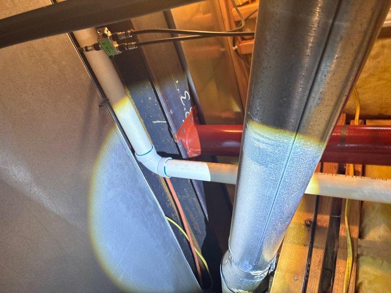 Conducted on-site assessment of laundry room floor drain installation. Upon inspection, identified that existing floor drain lacks proper drain pan and associated piping connections required for functional operation. Evaluated existing plumbing infrastructure including visible PVC Schedule 40 piping and drainage components in the utility space. Documented current conditions through photographic evidence showing concrete floor installation, exposed drain grate, and surrounding mechanical systems including HVAC ductwork and condensate lines in overhead spaces. Prepared estimate for installation of compliant drain pan system with proper piping connections to establish functional drainage for laundry room floor drain per plumbing code requirements.