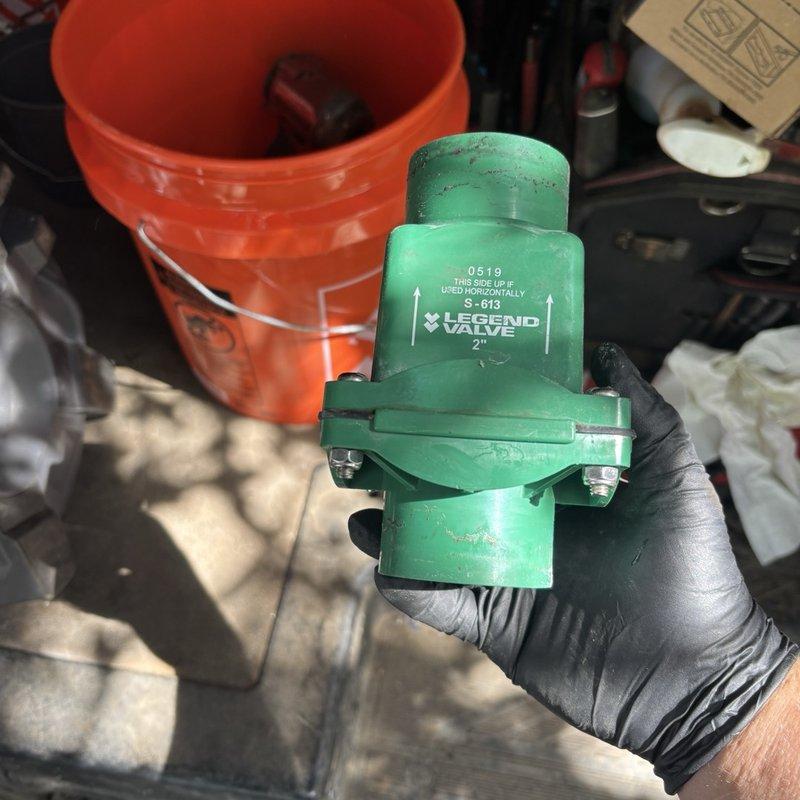 Responded to grinder pump malfunction in basement with suspected float or switch failure. Upon inspection, diagnosed faulty float switch assembly preventing proper pump operation. Removed defective green plastic float housing and replaced malfunctioning 2" Legend Valve component. Tested system operation to verify proper cycling and confirmed pump activated and deactivated correctly at appropriate water levels.