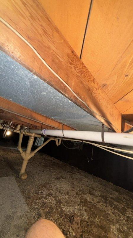 Installed a new 1-1/2" P-trap assembly on PVC drain line for shower in crawl space beneath residence. Connected trap using purple-primed couplings to existing drain system, ensuring proper drainage slope and secure watertight connections per plumbing code requirements.
