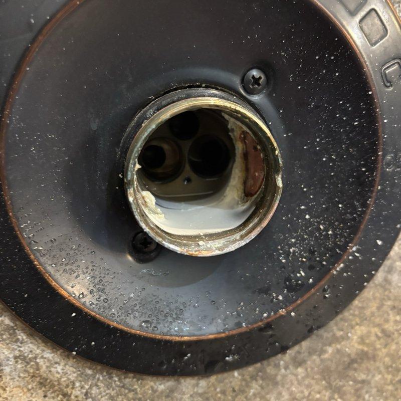 Responded to reported leak from shower on/off lever during operation. Upon inspection, disassembled and examined the shower valve assembly, revealing significant corrosion and mineral buildup on internal components including the cartridge housing and sealing surfaces. Removed deteriorated parts, cleaned valve body, and replaced worn cartridge and seals to eliminate water bypass during operation. Reassembled unit, tested for proper function, and verified leak was resolved with no water seepage when shower was activated.