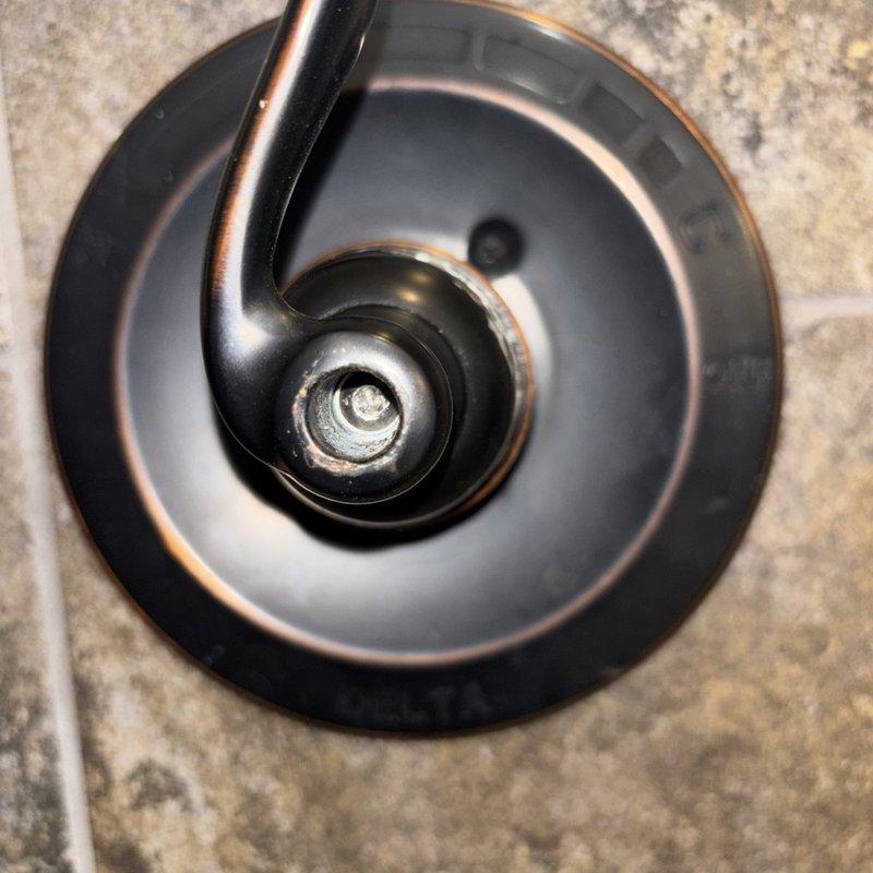 Responded to reported leak from shower on/off lever during operation. Upon inspection, disassembled and examined the shower valve assembly, revealing significant corrosion and mineral buildup on internal components including the cartridge housing and sealing surfaces. Removed deteriorated parts, cleaned valve body, and replaced worn cartridge and seals to eliminate water bypass during operation. Reassembled unit, tested for proper function, and verified leak was resolved with no water seepage when shower was activated.